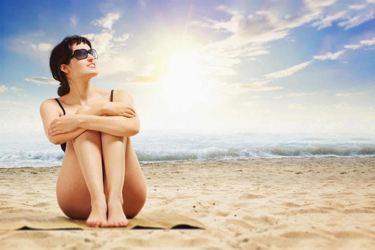 Femme au bord de la mer : quel soin après-soleil maison ?